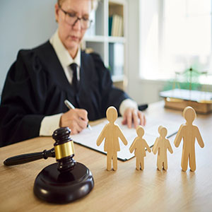 Female judge signing court documents for family law litigation and final divorce decrees.